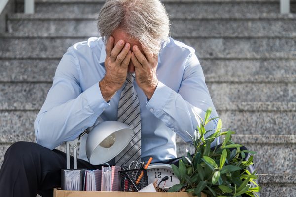 Fired frustrated businessman sitting on stairs