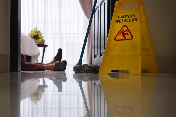 housemaid had accident at work while cleaning floor in hotel room. Side view, low angle