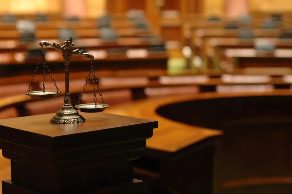 Empty courtroom with wooden benches and legal seating.