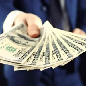 Hand holding cash to represent financial compensation.