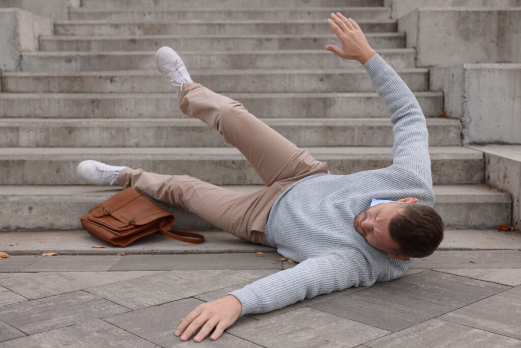 Man injured after a slip and fall accident on concrete steps outside a building.